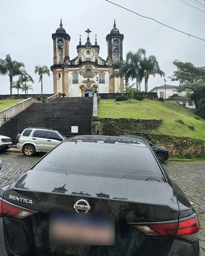 Táxi executivo preto em frente à escadaria da Igreja de Nossa Senhora do Carmo, em Ouro Preto